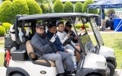 A group of men sitting in golf carts.