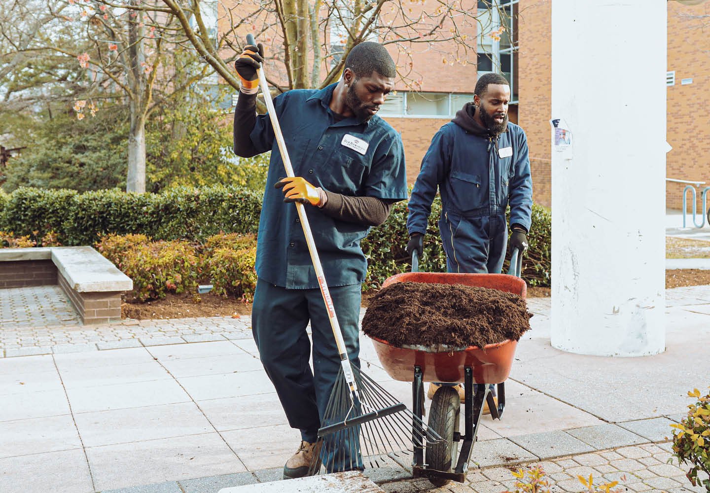 Two grounds workers tending landscape.