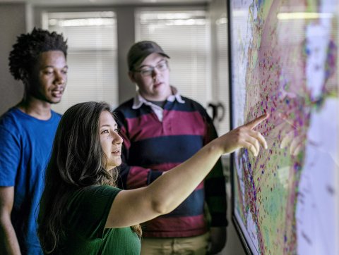 students in front of electronic map