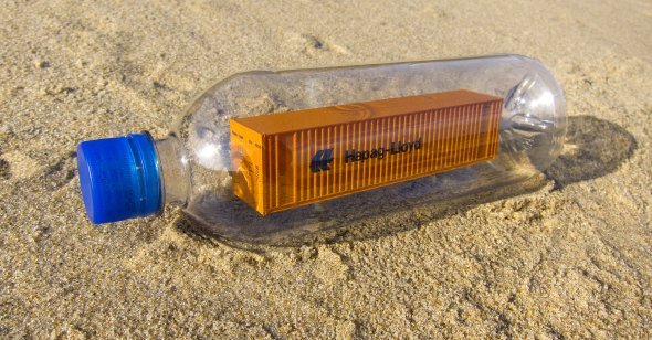 Photo of a shipping container inside a plastic water bottle.
