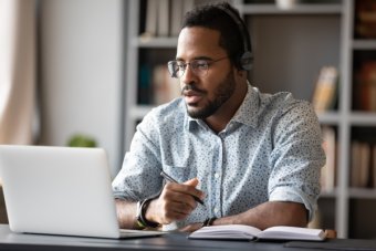 Focused businessman wear headphones study online watching we