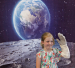 Elizabeth Tillson, 8, dons an astronaut glove and waves to her family at the selfie booth. Photo David B. Hollingsworth/ODU