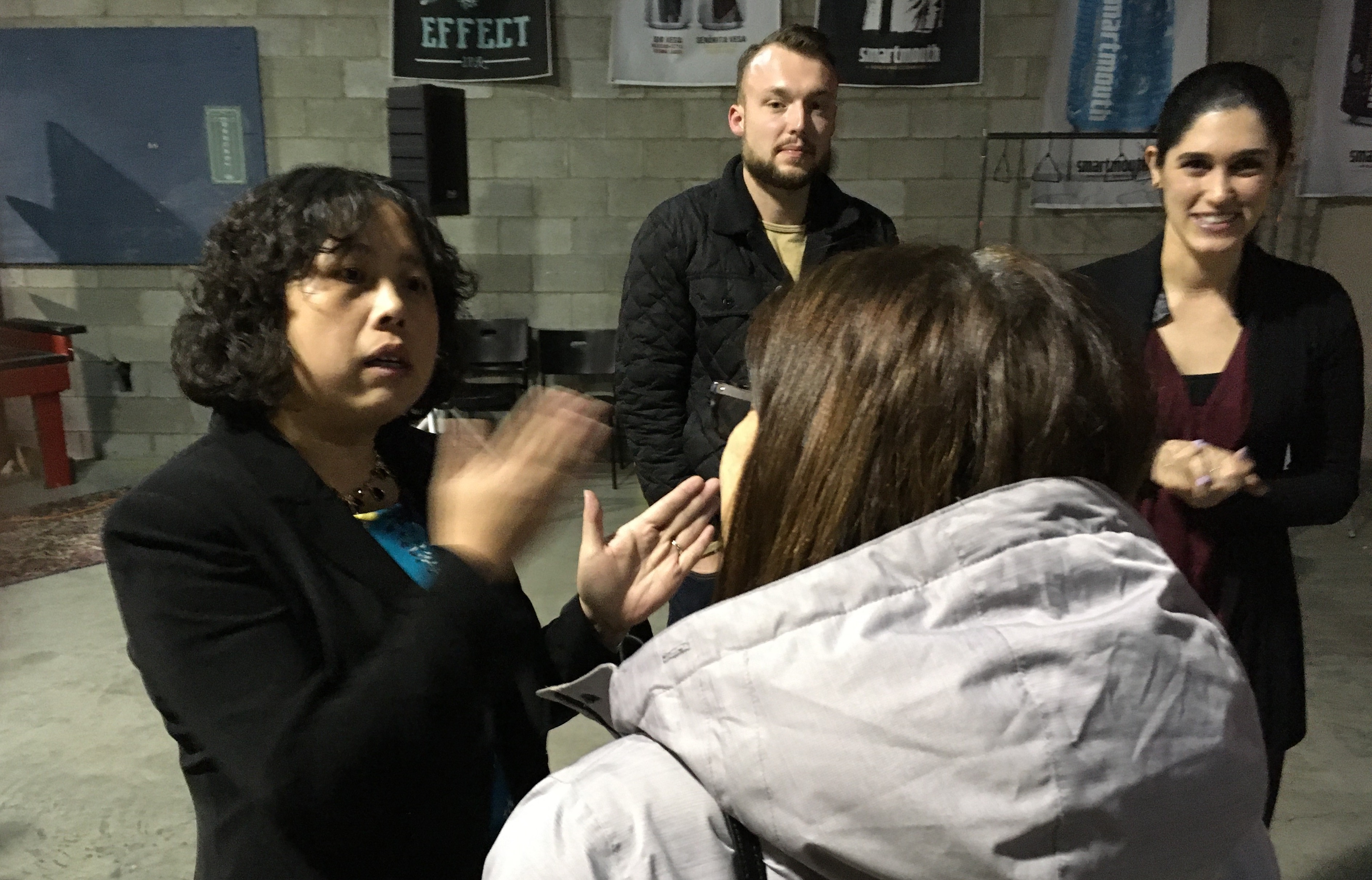 Yuping Liu-Thompkins, left, talks with audience members after her Dec. 3 Science Pub at Smartmouth Brewing Co. in Norfolk. 