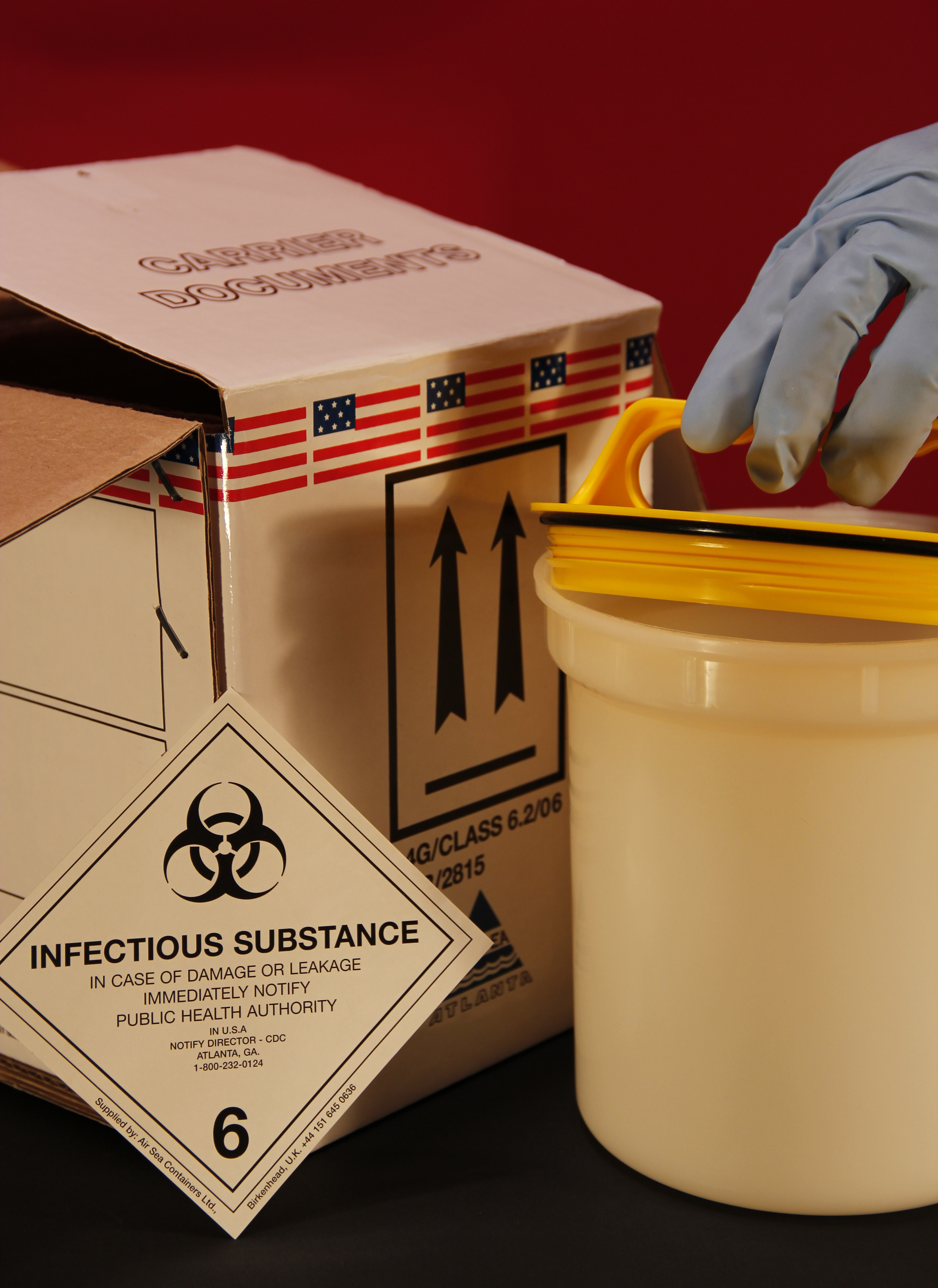 A Gloved Hand Opening A Biohazard Container