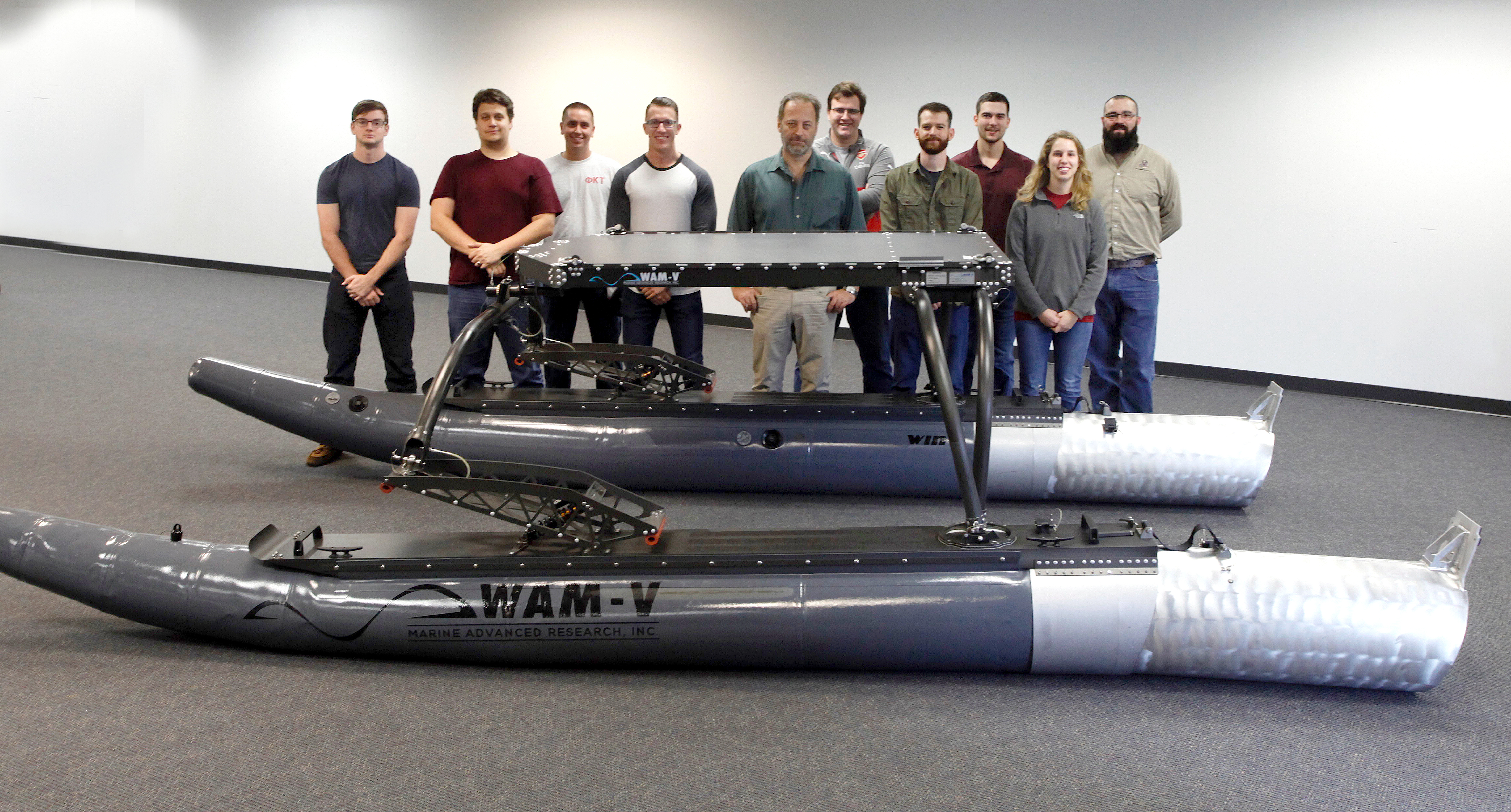 Photo of Research Professor Yiannis Papelis (center) and his students with their unmanned vehicle at VMASC