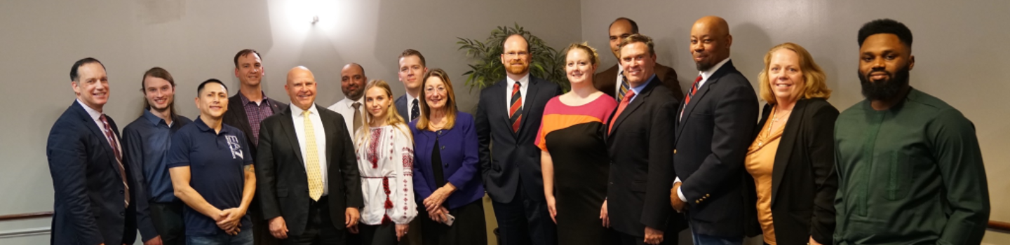 Group of working professionals smile while taking a group photo.