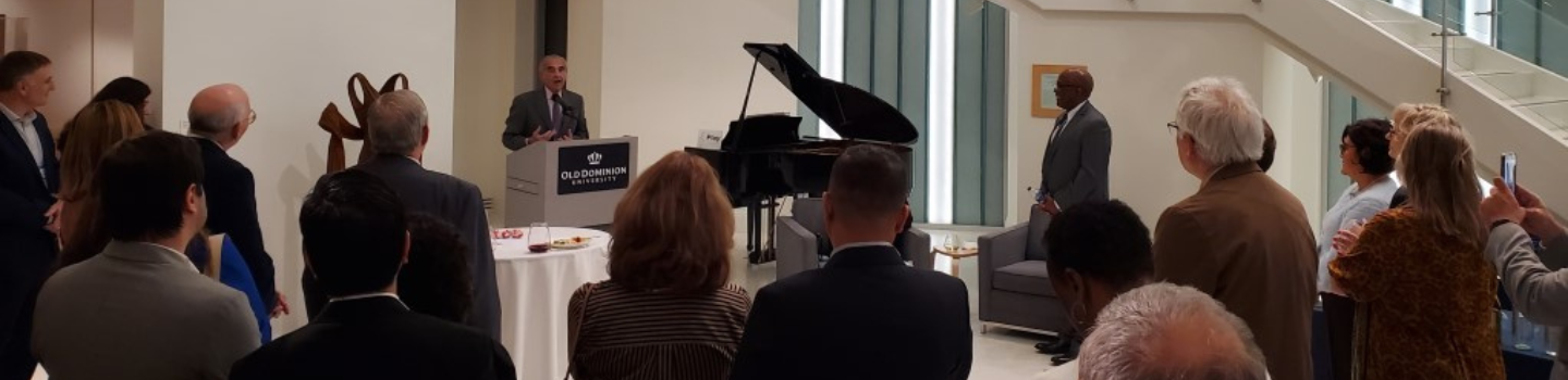 Man at podium speaks to standing audience