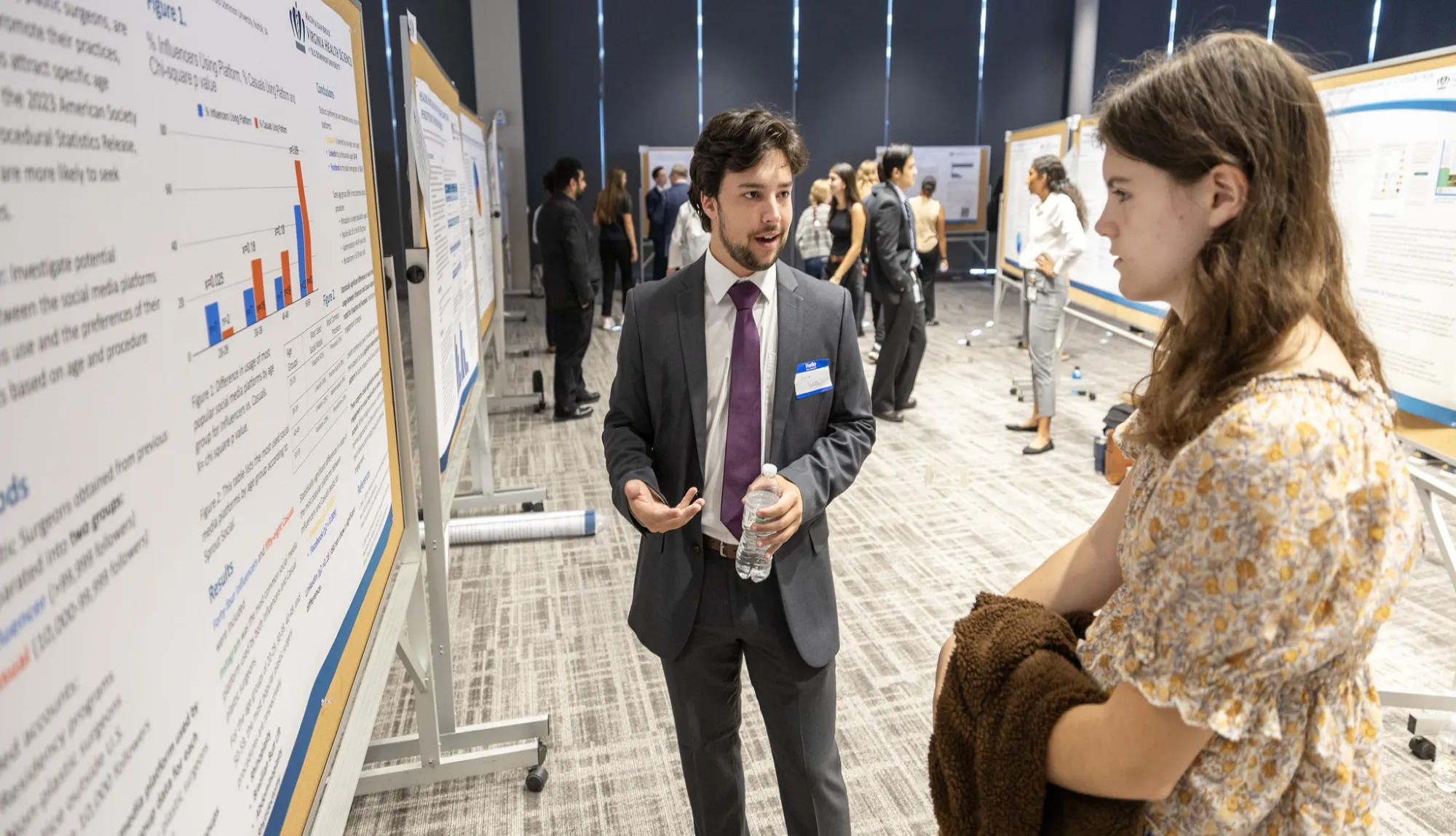 Student explains his presentation to female student