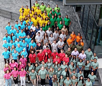 Overhead photo of GME interns grouped by color of tee shirts