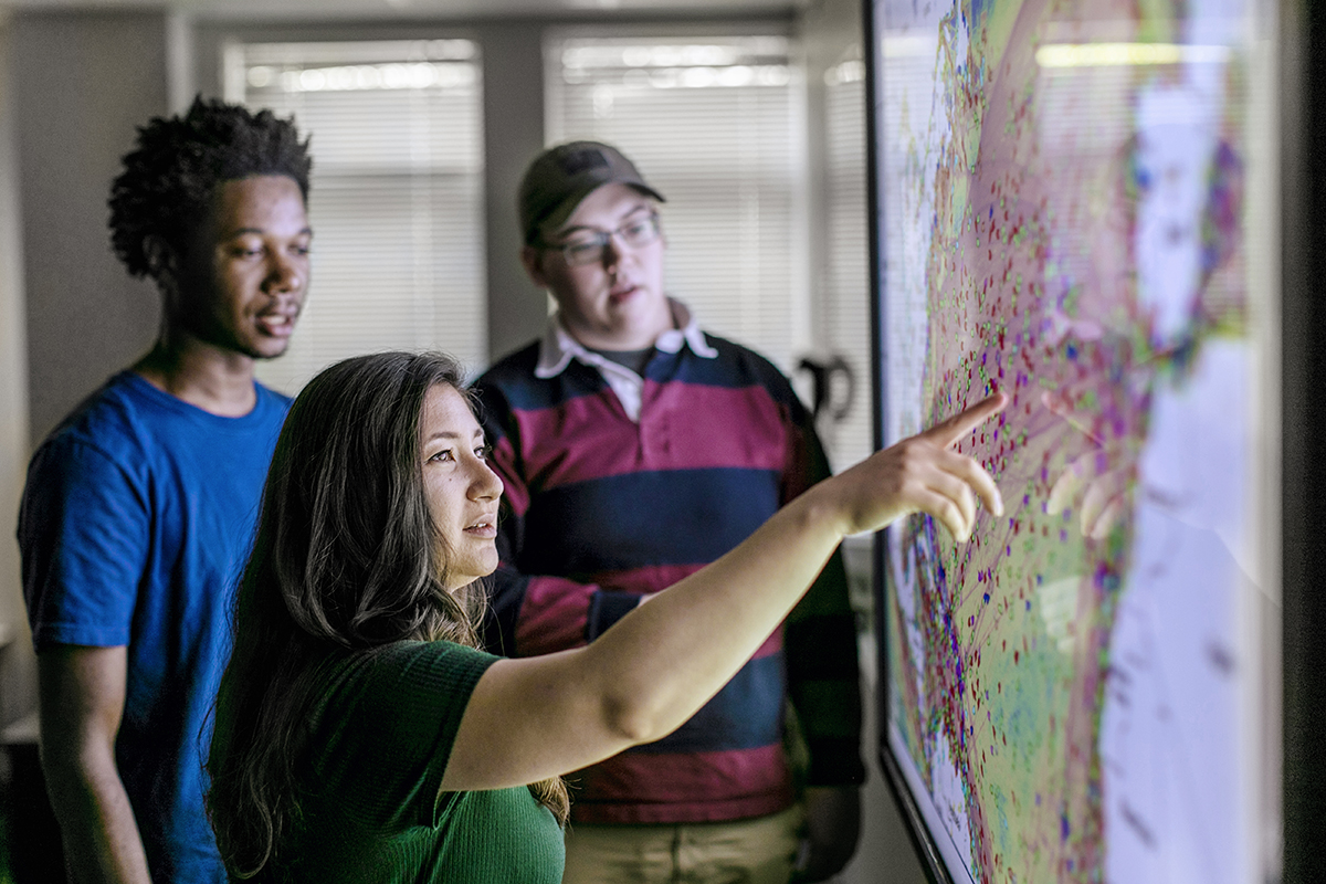 students in front of electronic map