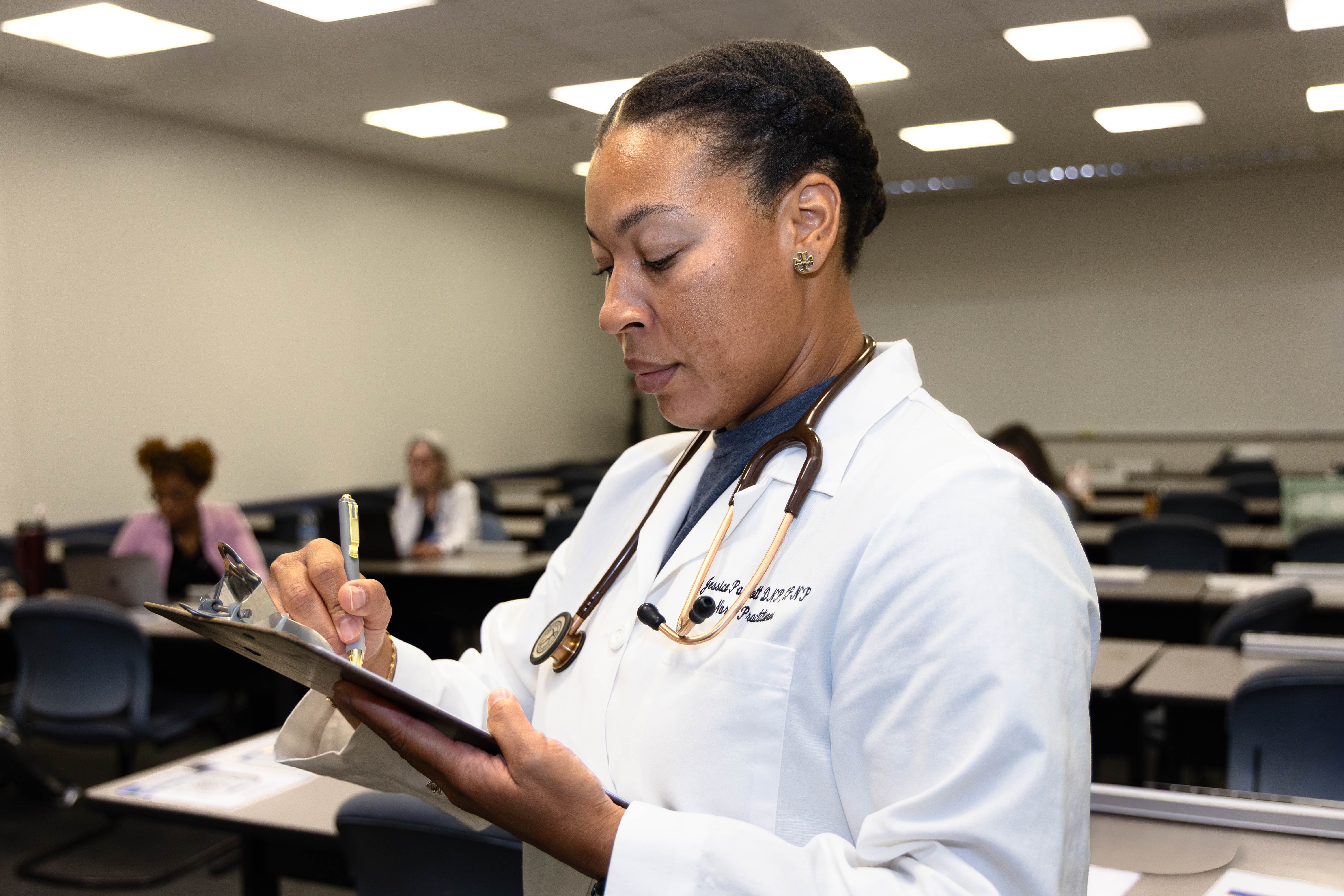 Nursing student writes on notepad.