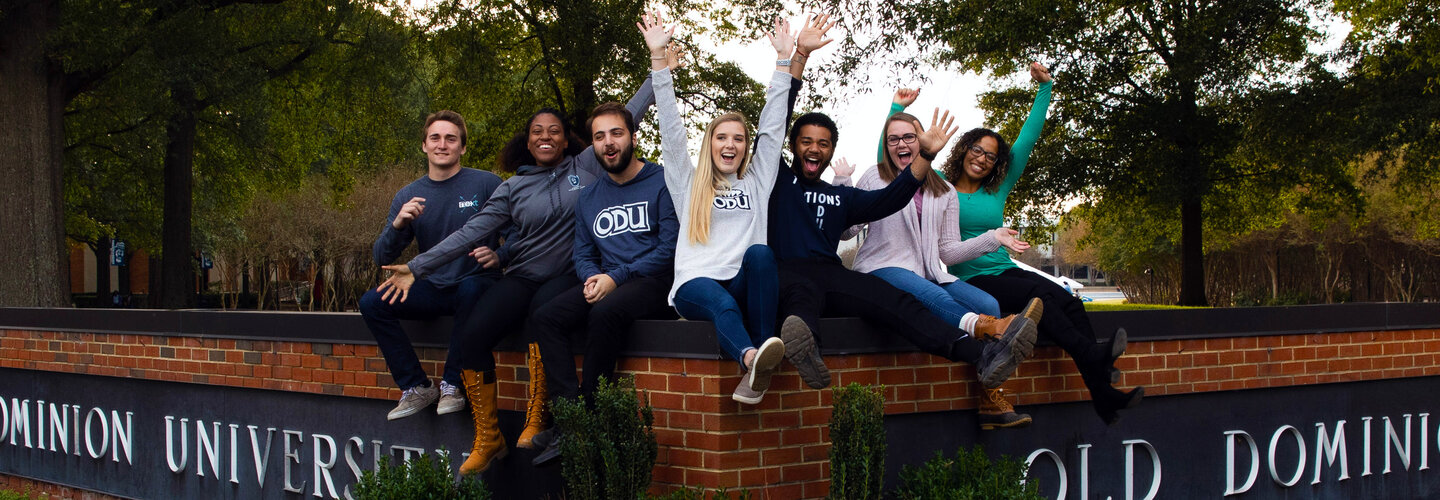 Students sitting on ODU sign