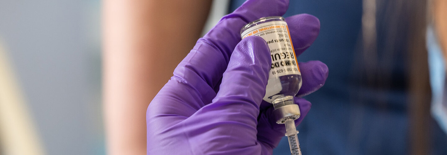 Nurse using syringe to draw medication from a vial
