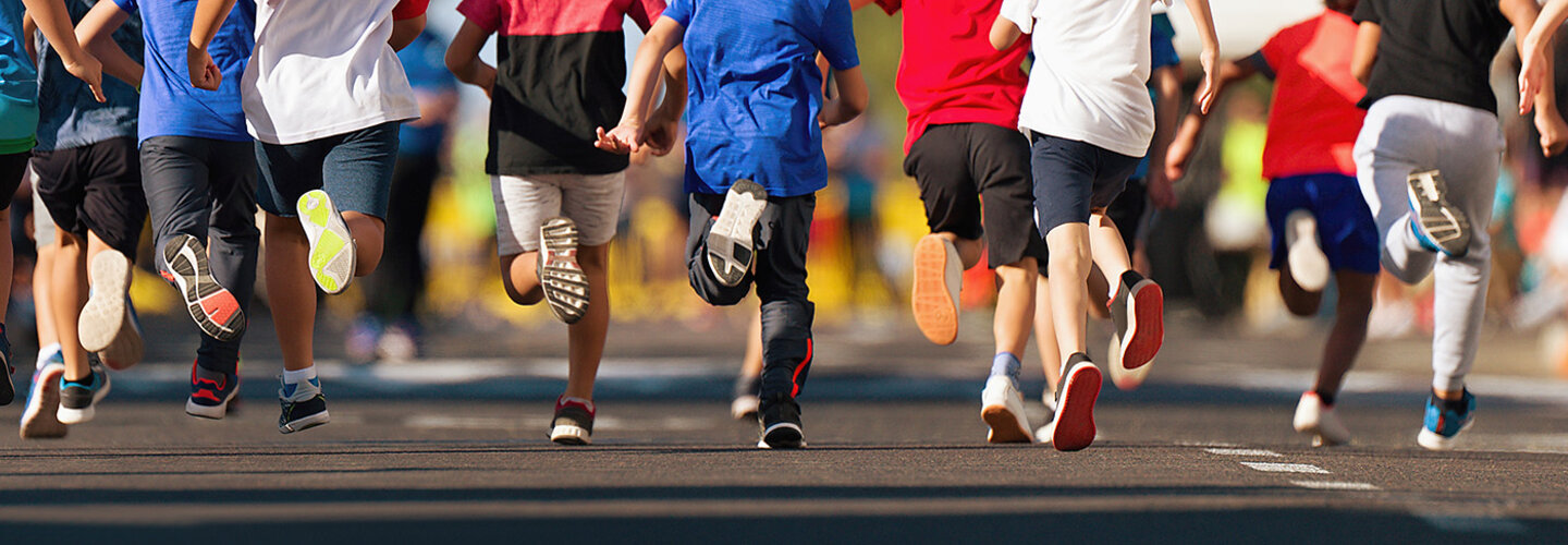 Children running on a road, feet only