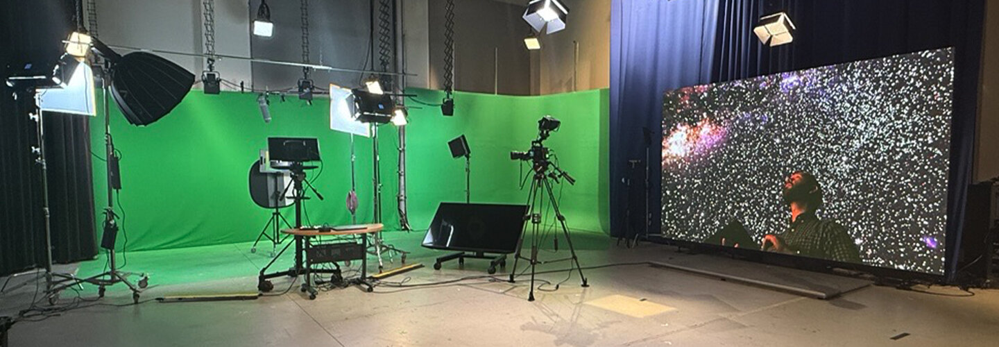 studio space with green screen, lights, and cameras