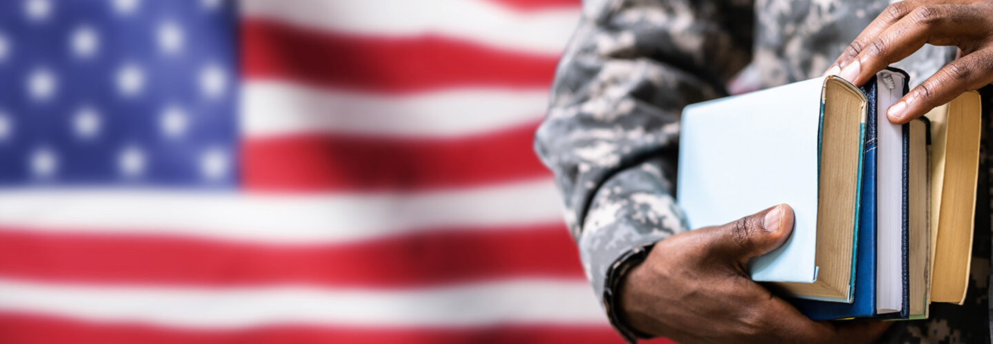 Service member holding book with flag