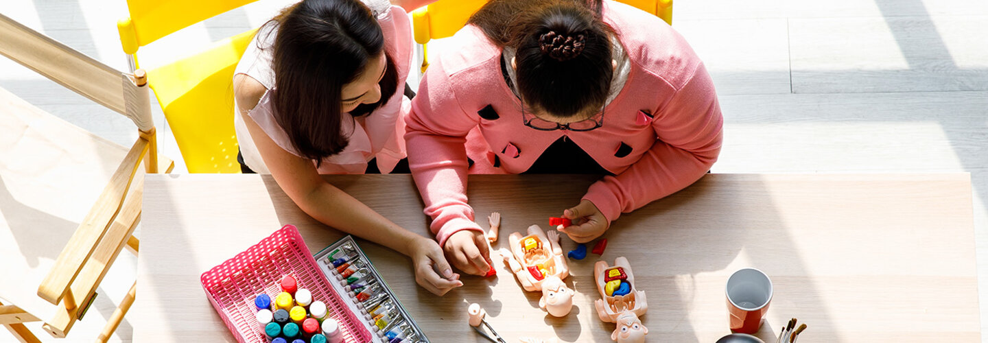 A teacher working with a student on blocks