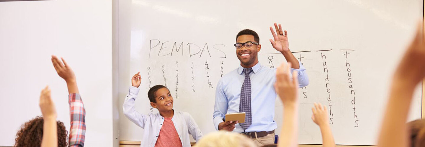 Male teacher in front of class. 