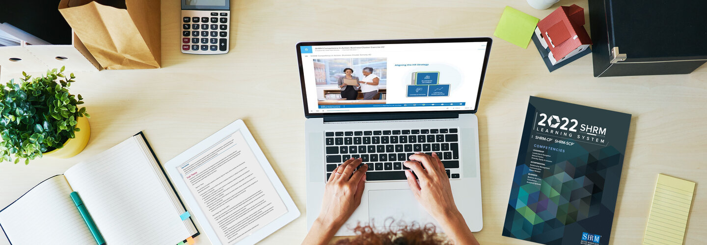 student at desk typing on a laptop