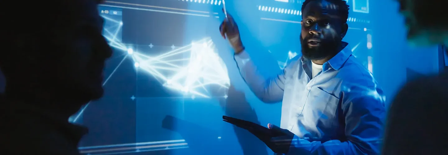 Man in front of projected chart explaining to other scientis