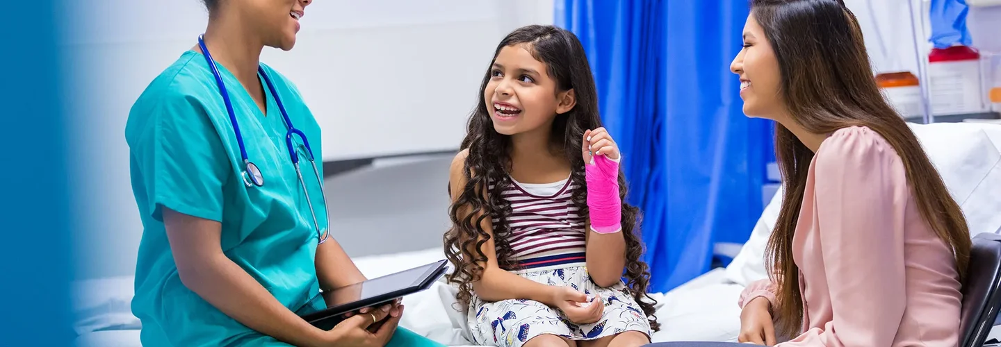 A fellow talks with a patient with a broken wrist and her mo