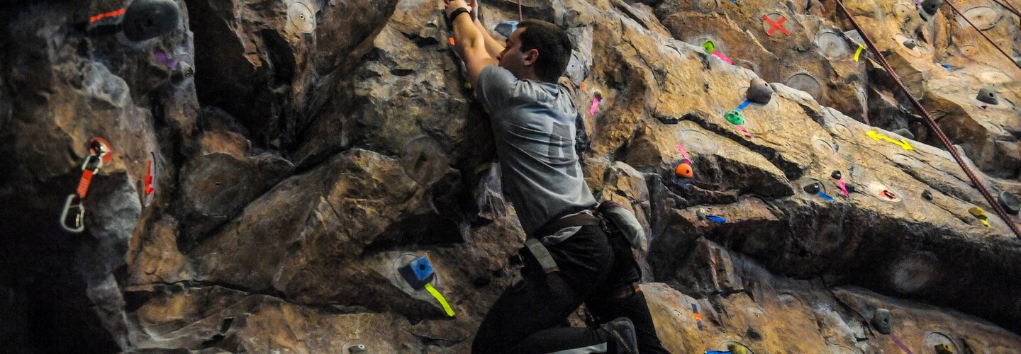 A person climbing the rock wall in Rec Well.