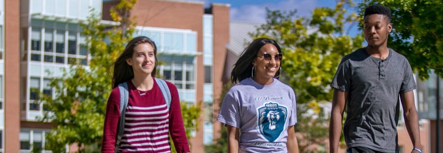Three students talking outside University Quad.