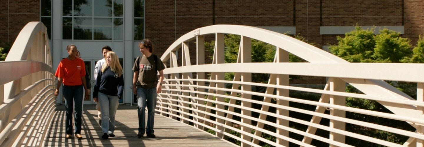 Students On-Campus walking across a bridge. 