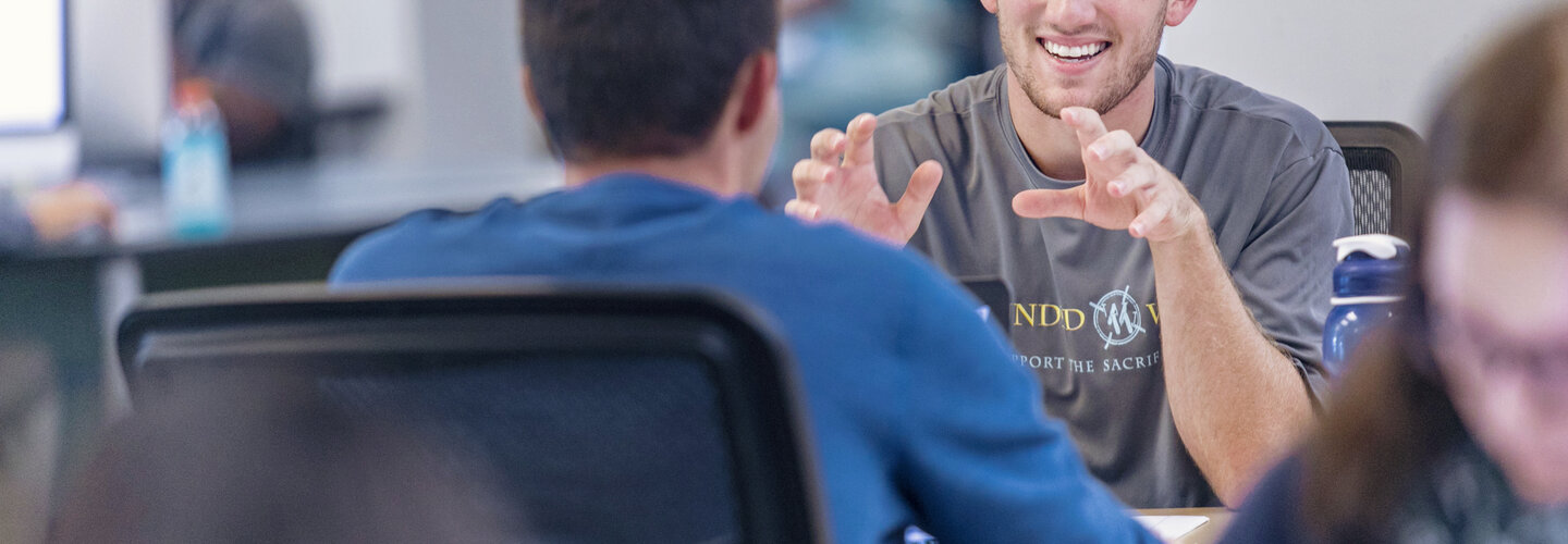 Students talking at a desk.