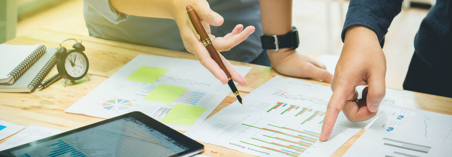 A group of people looking over data on a large table. 
