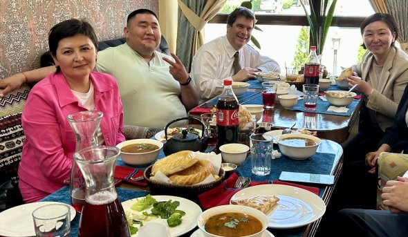 ODU professor Jim Blando, Ph.D., sits with other people at a table eating lunch 