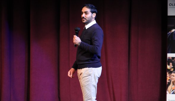 A man speaks on a stage.