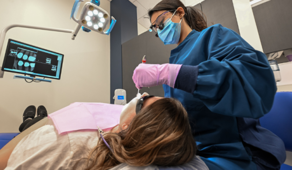 Female dental technician works on patient