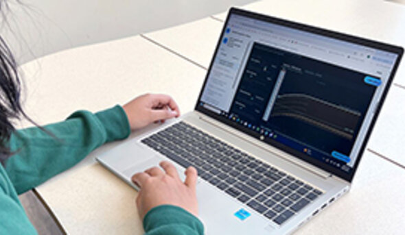 Hands typing on a laptop