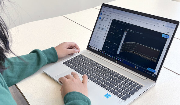 Hands typing on a laptop