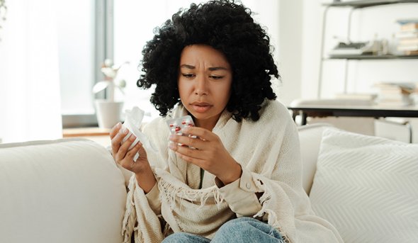 Sick woman reading medication label.