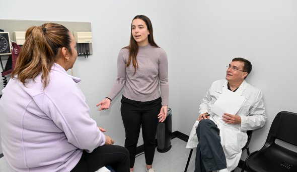 A woman talks to a patient in a doctor's office.