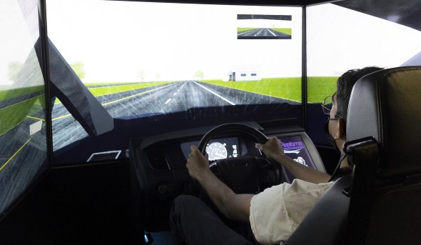 A student tests out a driving simulator. 