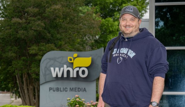 Old Dominion University student George Degaraff stands in front of the WHRO sign
