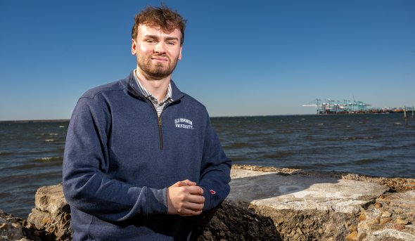 Joshua Seaford stands in front of water
