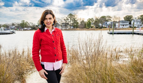 Laura Costadone in front of marshy area with house in background