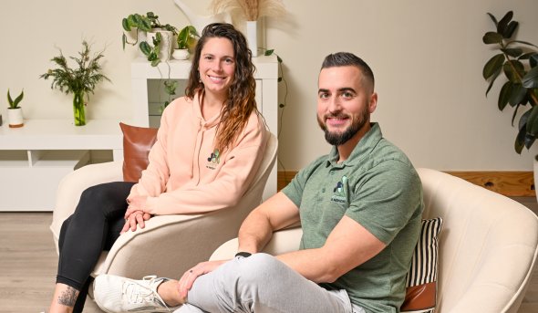ODU alumni Amanda Bennett and Marc Adams sit in chairs inside their physical therapy business.