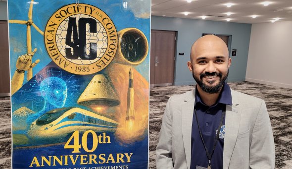 Mohammad Nazmus Saquib smiles for photo beside an American Society for Composites banner.