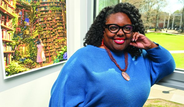 Remica Bingham-Risher stands next a window in her office 