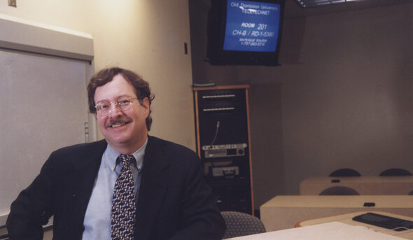 Dr. Stephen W. Tonelson, Special Education instructor, at a distance learning broadcast studio located in the Gornto Teletechnet Building.