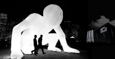 large scale white inflatable sculpture with two people standing in front