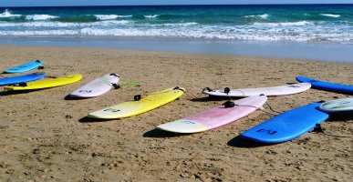 Surfboards lie on the beach.