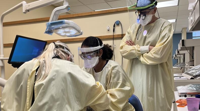 dental hygiene students work on a patient 