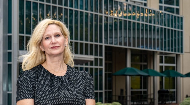 Woman poses for photo in front of building