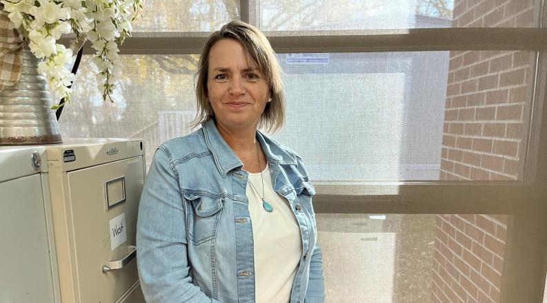 a woman stands in front of a window